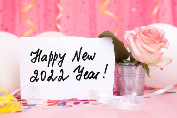 Happy new year 2022 - card with text, pink air balloons and decorations on colorful background with rose