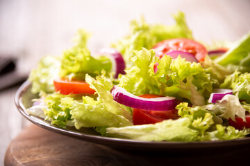 Green vegetable salad with lattuce, tomatos, onion. Healthy food concept