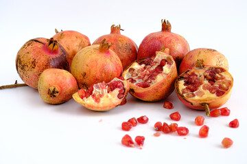 Pomegranate apples and seeds or grains isolated on white background, profile view of lots of fresh pomegranate apples. Copy space on bright white. No people.