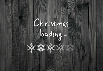 Christmas concept with loading bar in snowflakes form showing progress on dark black wooden boards background and inscription, xmas holiday design in minimalistic style.