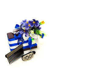 Gift box. celebration concept decorated with flowers. in white and blue colors. next to the feminine decoration. hairpin. on an isolated white background
