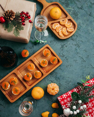 Green Christmas background. Tartlets with red caviar tangerines and champagne.