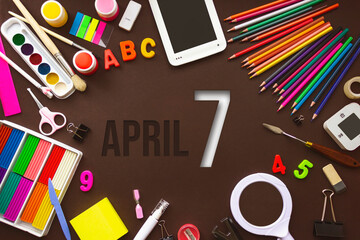 April 7th. Day 7 of month, Calendar date. School notebook and various stationery with calendar day. School and office supplies frame. Spring month, day of the year concept.