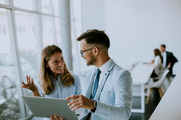 Young business couple working and discussing by laptop in the office