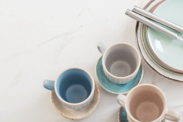 ceramic cups and plates on white marble table