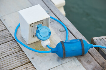 Electrical power socket bollard on pier. Charging station for boats in Marina. Electrical outlets to charge ships in harbor.