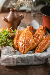 Fresh fried meat pies on rustic background