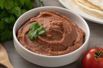 Bowl with Mexican brown refried beans paste close up 
