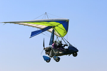 Ultralight airplane flying in a blue sky	