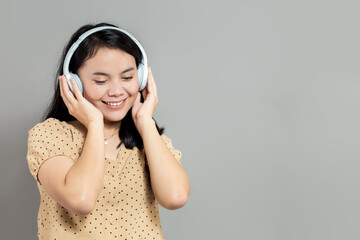 Indonesian woman listening to music on wireless headphones