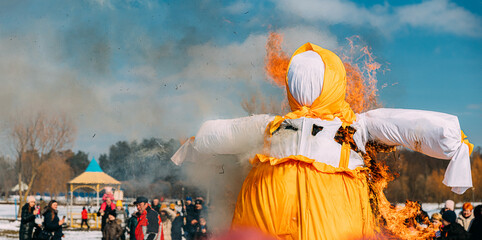 Burning Effigies Straw Maslenitsa In Fire On Traditional National Holiday Dedicated To Approach Of Spring - Slavic Celebration Shrovetide. Belarus. Panorama. Panoramic View - obrazy, fototapety, plakaty
