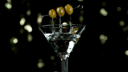 Freeze motion of falling olives into martini drink