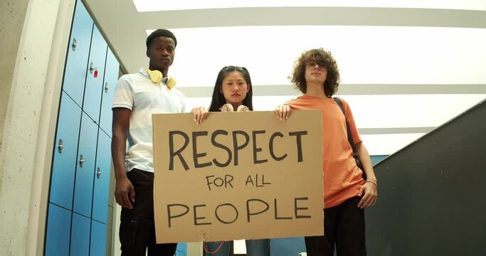 Multi-ethnic students holding a sign with the slogan respect for all people
