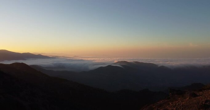 Aerial shot of the peak of the mountain range in Madari Cyprus during sunset. Over the clouds, looking the horizon