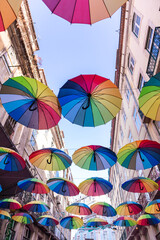 Fototapeta na wymiar Rainbow umbrellas decorating a street in lisbon, portugal