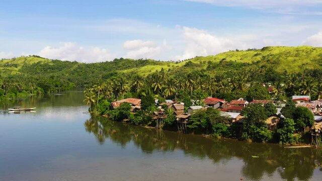 Countryside on a large tropical island. Small village on the green hills by the river. Tropical landscape in sunny weather. Village by the river. The nature of the Philippines, Samar