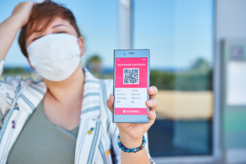 Upset woman tourist with smartphone displaying on app mobile expired digital vaccination...