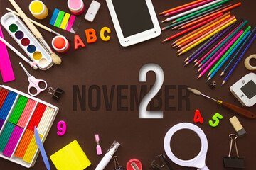 November 2nd. Day 2 of month, Calendar date. School notebook and various stationery with calendar day. School and office supplies frame. Autumn month, day of the year concept.