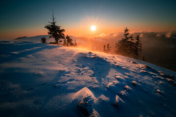 Breathtaking panorama scene in the mountains during winter with the sunrise during a cold clear day