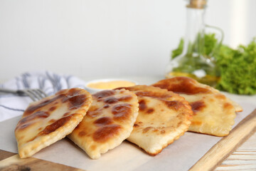 Delicious fried chebureki on white wooden table