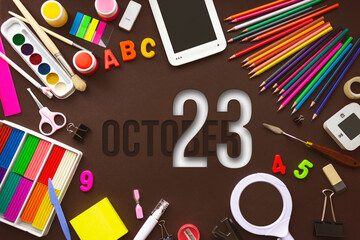 October 23rd. Day 23 of month, Calendar date. School notebook and various stationery with calendar day. School and office supplies frame. Autumn month, day of the year concept.