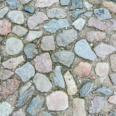 a fragment of a cobblestone pavement of different sizes and shapes. Close-up. Weathered surface