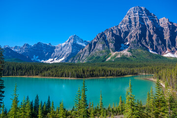 Fototapeta na wymiar Canada, Alberta. Glacial Silt colors Waterfowl Lake blue with Howse Peak in view on Icefields Parkway.