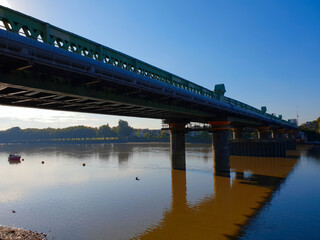 Early morning view of Fulham bridge over the river Thames with reflection in the water