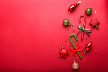 Flat lay composition with  candy canes and Christmas decor on red background
