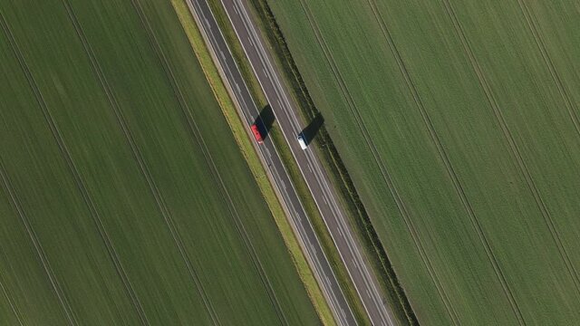 Green fields and four lanes highway from above. Cars and truck. Second part  truck following  shot.
