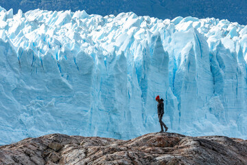 A woman standing on the rock formation next to the Perito Moreno Glacier 