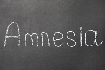 Obraz premium Word Amnesia written on blackboard, top view