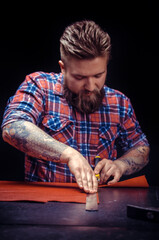Craftsman working with leather working with leather in the place of work