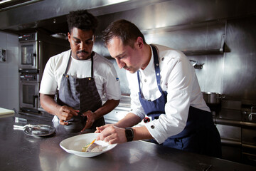 Diverse colleagues cooking soup with fish in restaurant
