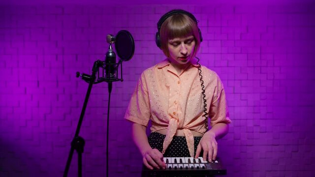 positive caucasian singer makes thumbs up gives approval shows excellent gesture says nice job gives positive feedback shares good opinion. female in headphones in studio with microphone, synthesizer