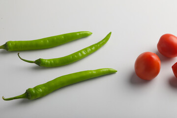 Fresh Green chilli and tomatos on white background.