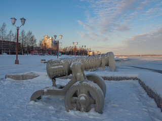 Metal  cannon sculptures covered with ice due to a winter storm on the embankment of the city of Petrozavodsk in the Republic of Karelia on a frosty day