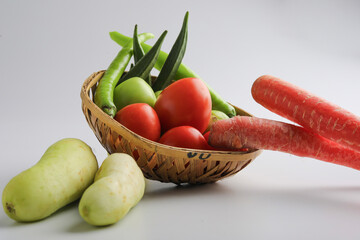 Raw vegetable in wooden bowl on white background.