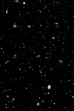 Light real snowfall in short exposure time against black background. Works well as an overlay. Vertical alignment.