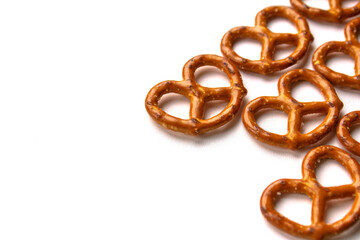 Crispy salty pretzels are laid out on a white background. Top view. Concept: quick snack, food photography, holidays and vacations, cafes and bistros, Christmas food.