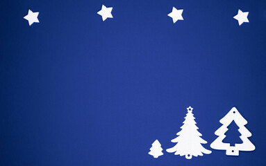 Choinki i gwiazdki świąteczne na niebieskim tle.