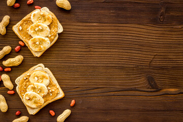 Smooth peanut butter on sandwiches with nuts. Top view