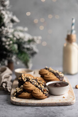 Fototapeta na wymiar Spritz biscuits sablés ambiance de Noël au chocolat et noisette avec sapin et bouteille de lait