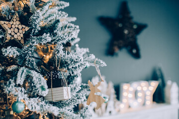 Beautiful snowy Christmas tree against blue background with beautiful ornaments for the holidays. 
