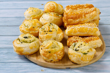 Pies and buns on a wooden table. Fresh pastries are prepared at home. A delicious crispy appetizers. close up