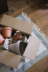 Time to make gifts. Online shopping, contactless payment, delivery to the address. Terracotta clay ceramic pots in a cardboard box. Pots for houseplants.