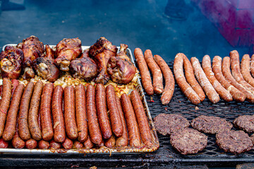 Piles of Turkey Legs, Sausages, and Hamburgers Are Grilled at an Outdoor Food Stall at the 2019 San Diego County Fair