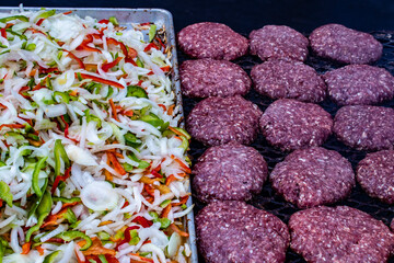 Raw Hamburger Patties and Chopped Onions and Peppers Are Prepared to Go on the Barbecue Grill at the 2019 San Diego County Fair