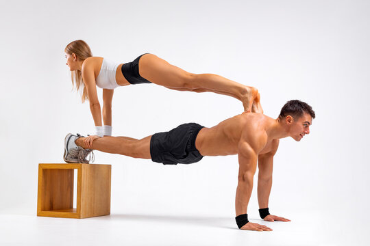 Athletes a guy and a girl are in the plank exercise. Fit couple at the gym isolated on white background. Fitness concept. Healthy life style.