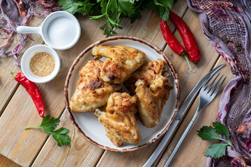 Hearty snack: chicken wings baked in the oven, buffalo wings on a plate. Close-up